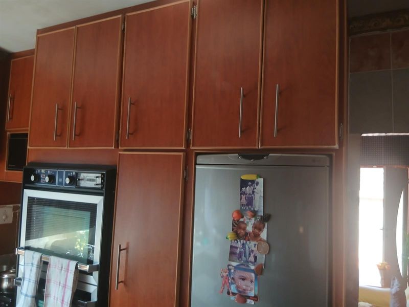 A kitchen area featuring wood-finish built-in cabinetry and a built-in oven unit.