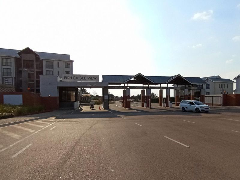 The main entrance and security gatehouse of the Fish Eagle View apartment complex, featuring paved access lanes and modern brick and metal architecture.