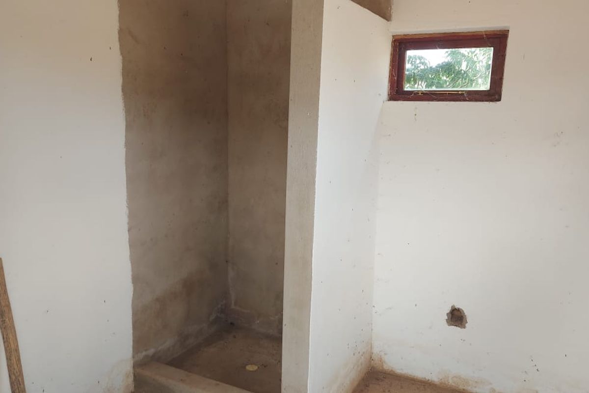 An unfinished bathroom space featuring a shower alcove, requiring completion of wall finishes and flooring to become a functional area.