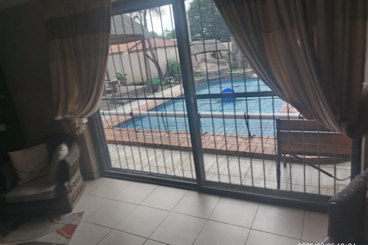 Living area featuring tiled flooring and large sliding glass doors with security gates, providing direct access to the outdoor pool area.
