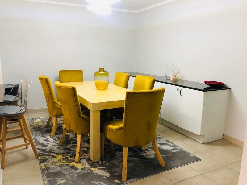 A dining area featuring tiled flooring and a built-in sideboard with a dark countertop, providing functional storage space.