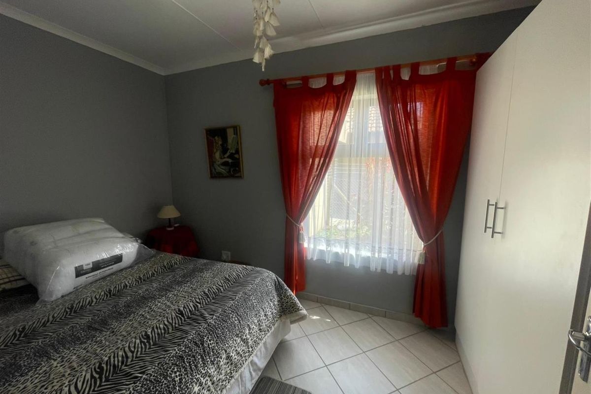 A functional bedroom featuring tiled flooring and a built-in wardrobe, providing essential storage space and a neutral foundation for personal styling.