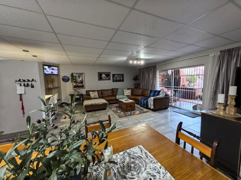 Spacious open-plan living and dining area featuring tiled flooring and large sliding glass doors providing access to the patio.
