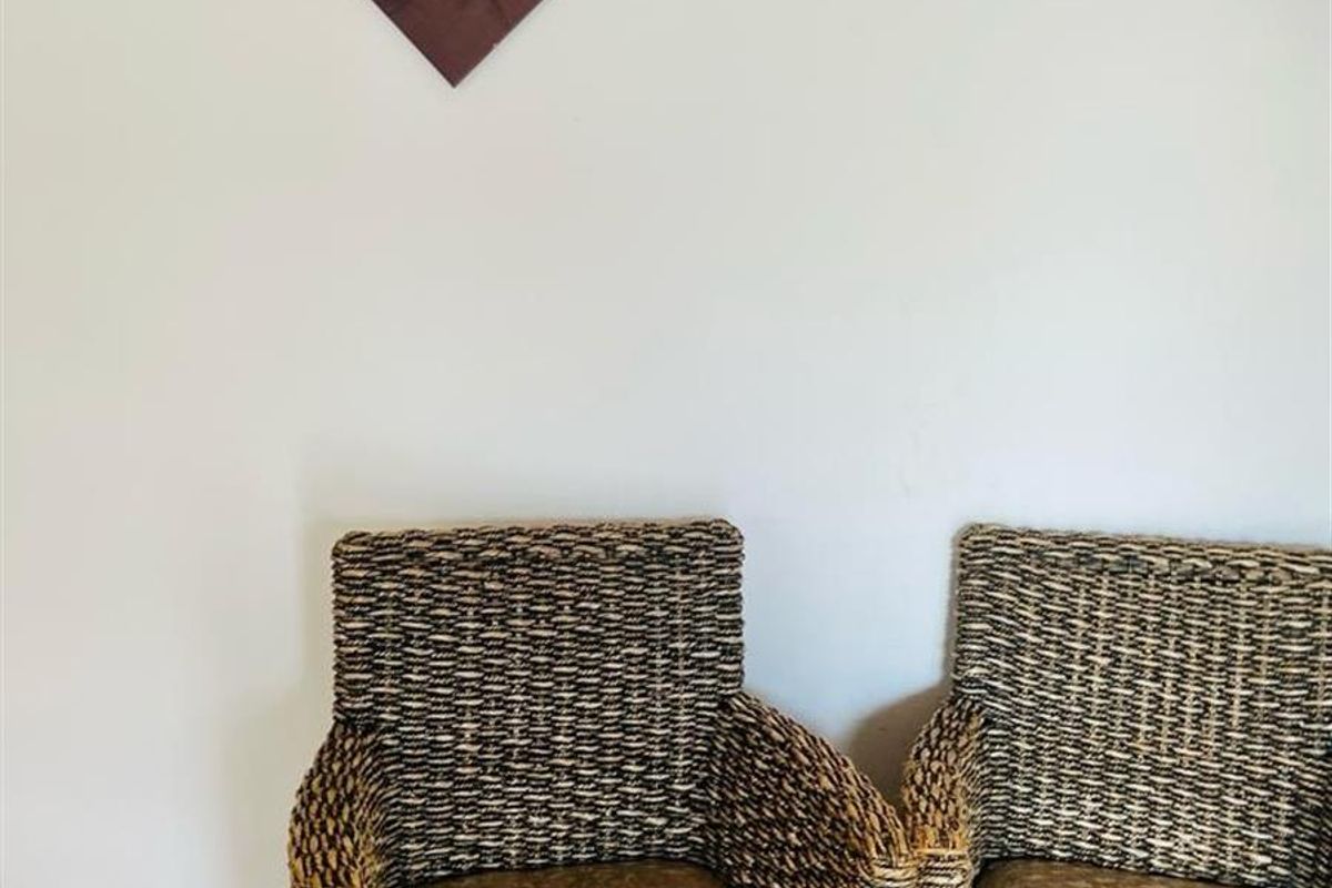 A simple living area featuring light-toned laminate flooring and neutral wall finishes.