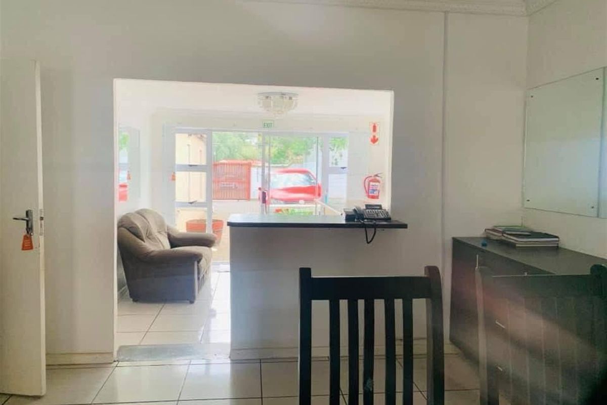 A functional reception or entry area featuring a service counter, tiled flooring, and direct access to an exterior space.