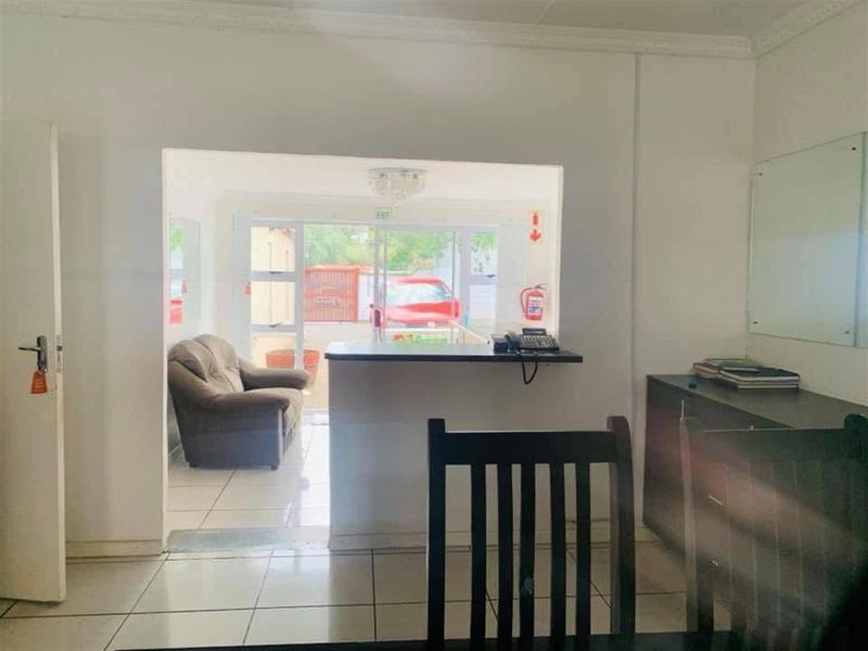 A functional reception or entry area featuring a service counter, tiled flooring, and direct access to an exterior space.