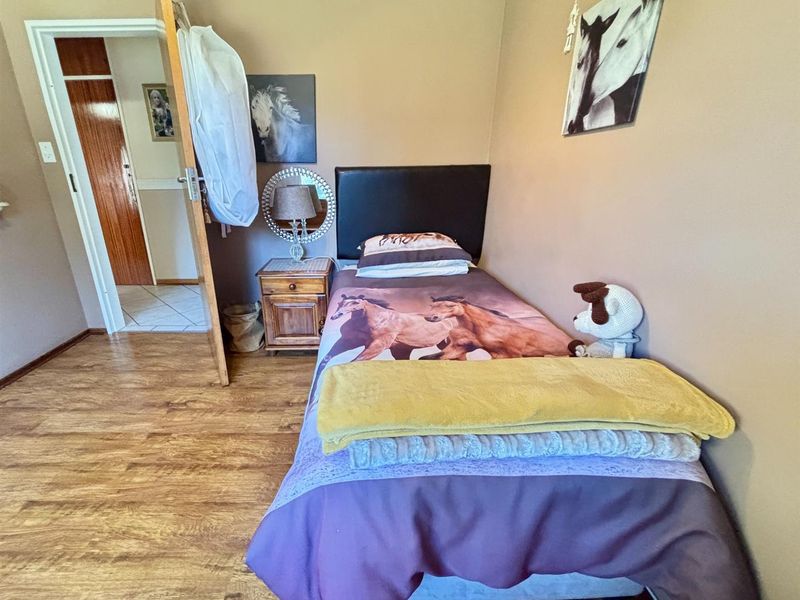A standard bedroom featuring laminate flooring and neutral wall tones, providing a functional and comfortable living space.
