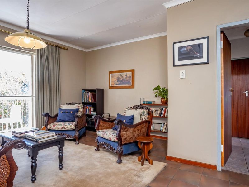 A living room featuring tiled flooring, a pendant light fixture, and sliding glass doors providing access to a balcony.