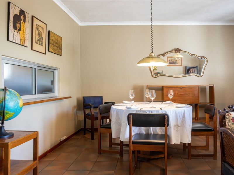 A dining area featuring tiled flooring, a pendant light fixture, and a horizontal sliding window.