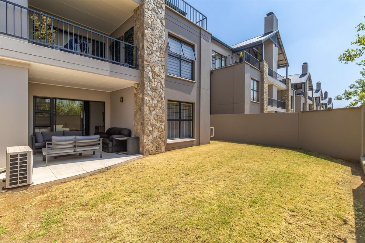 Ground floor apartment featuring a covered patio area and a private garden space with stone-clad architectural detailing.
