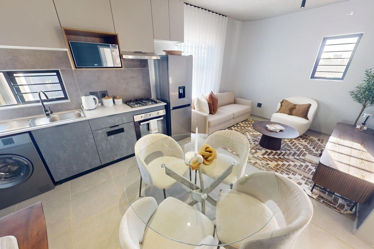 Modern open-plan apartment featuring a sleek kitchen with integrated appliances, tiled flooring, and a seamless transition into the living and dining area.