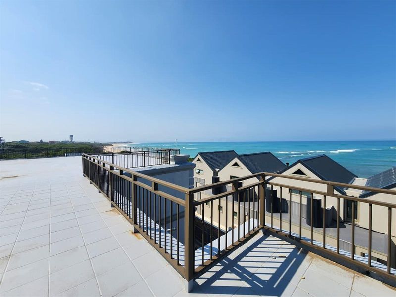 Spacious rooftop balcony featuring tiled flooring and metal balustrades, offering expansive panoramic ocean views.