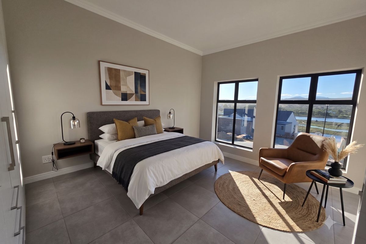 A modern, well-lit bedroom featuring large windows with scenic views, neutral tiled flooring, and built-in storage.