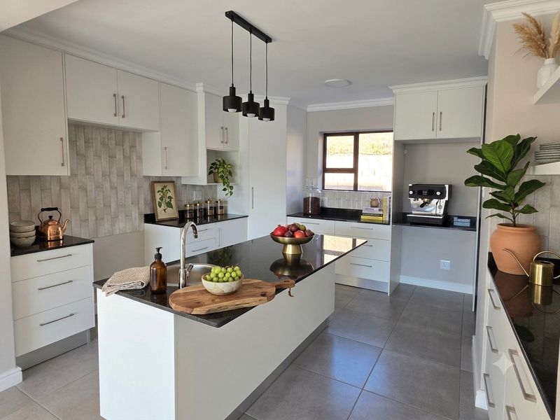 Modern kitchen featuring a central island with granite countertops, sleek white cabinetry, tiled backsplash, and contemporary pendant lighting.