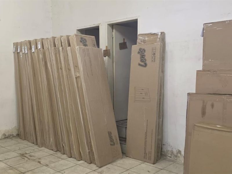 A utilitarian storage or back-of-house space featuring tiled flooring and plain walls, currently used for storage.
