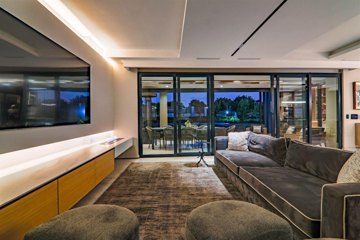 Modern living room featuring recessed ceiling lighting, built-in cabinetry, and large sliding glass doors opening to an outdoor patio area.