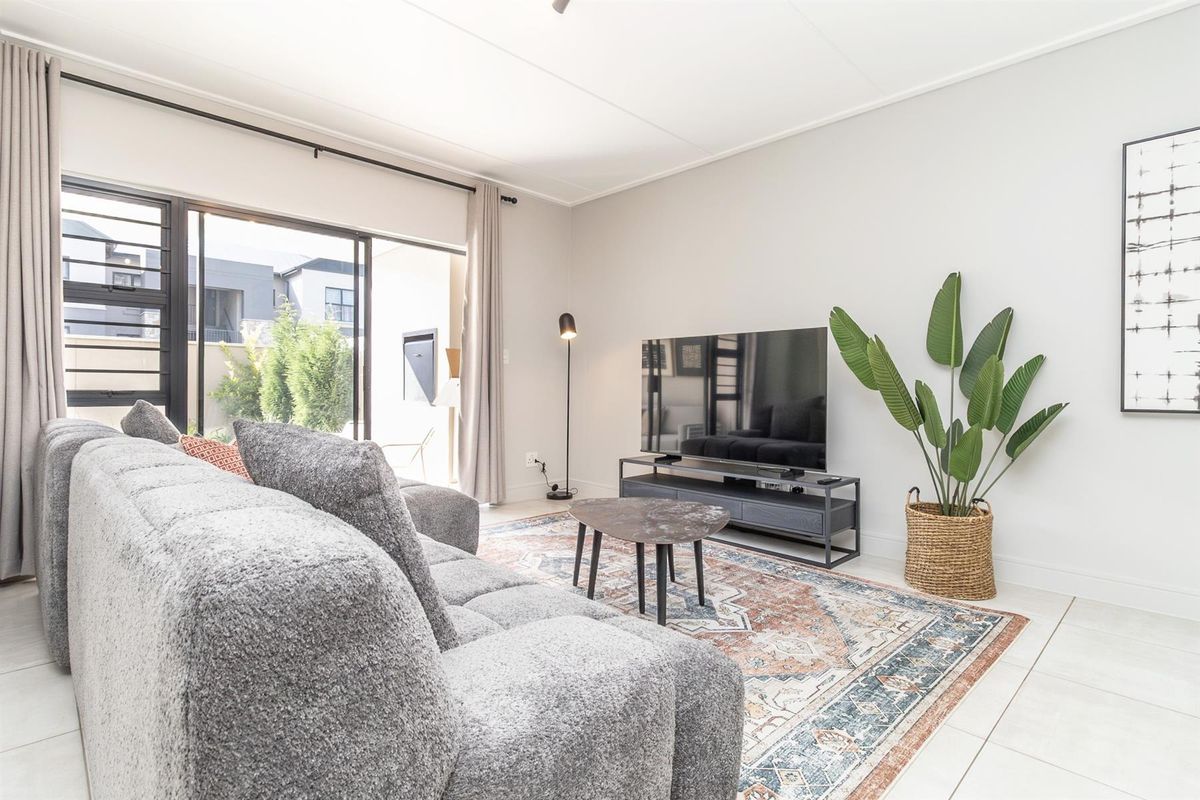 A bright and modern living room featuring large sliding glass doors that provide access to the outdoor area and ample natural light.