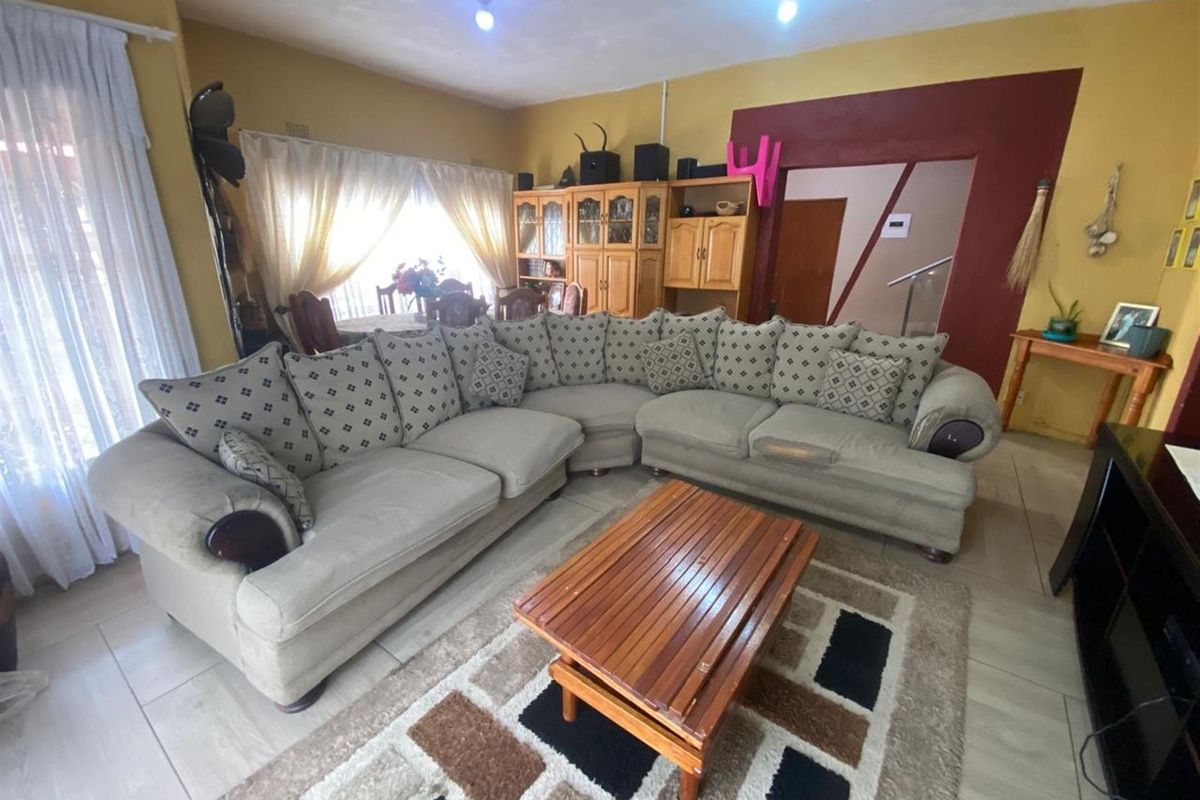 A spacious living area featuring tiled flooring and an open-plan layout, providing a comfortable space for relaxation and family gatherings.
