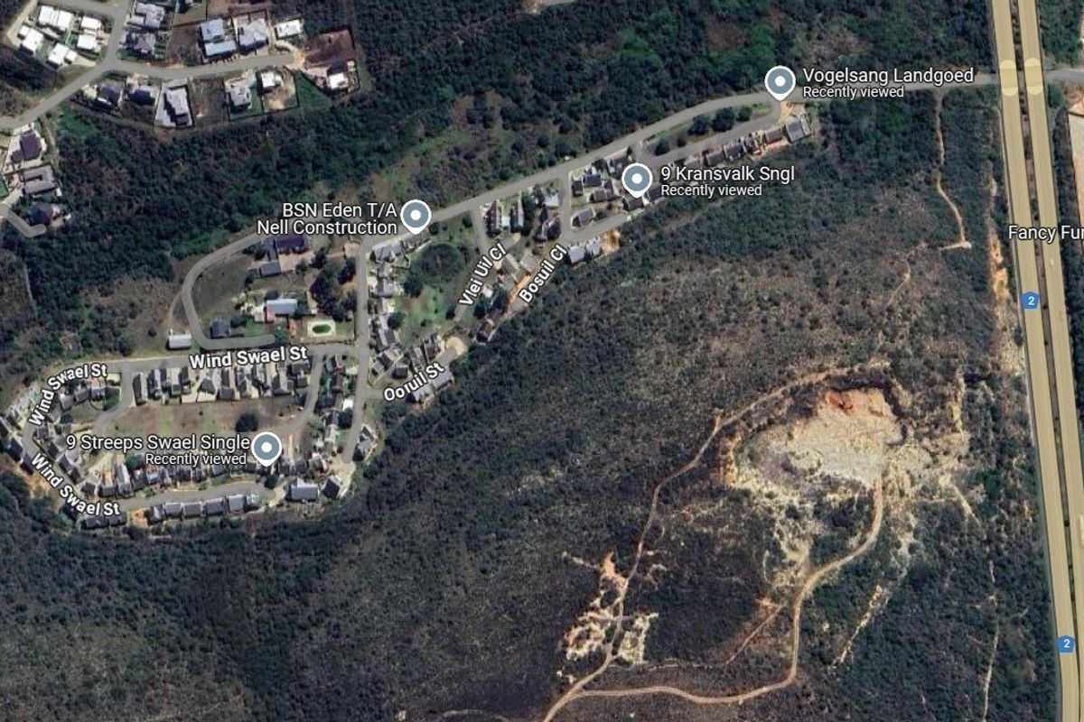 An aerial view of the residential area and surrounding landscape, showing the layout of the neighborhood and nearby road infrastructure.