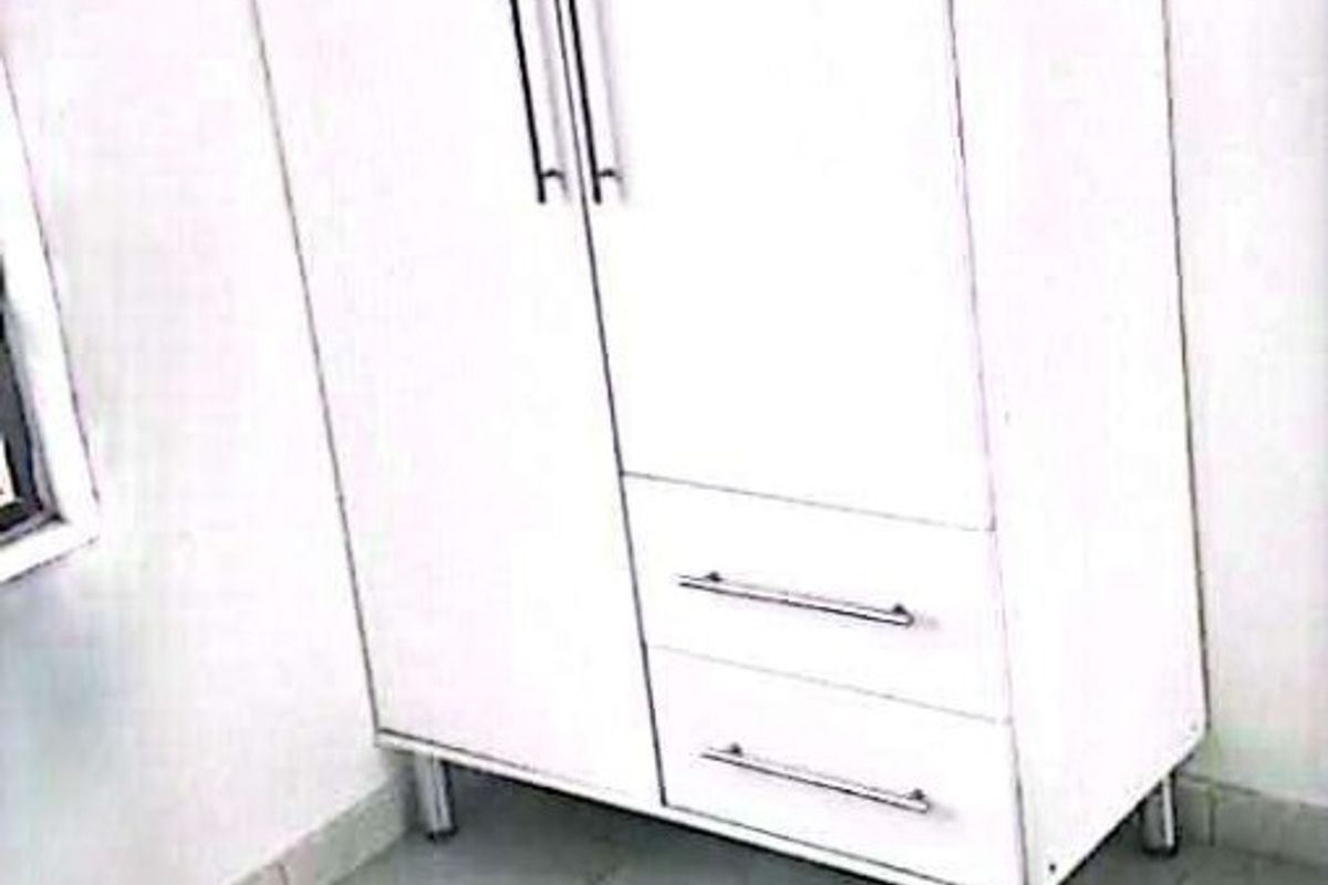 A bedroom space featuring tiled flooring and a freestanding wardrobe unit.