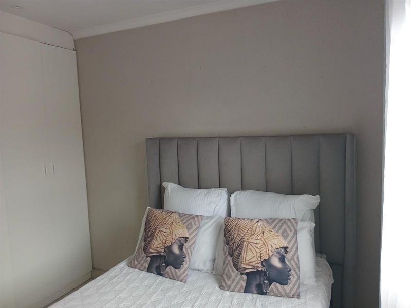 A bedroom featuring neutral wall tones and integrated built-in cupboards, providing functional storage space.