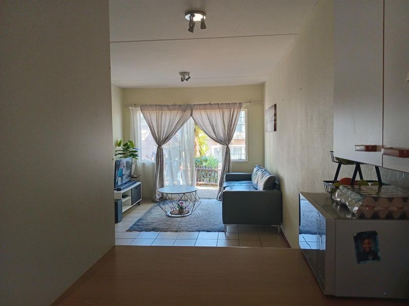 Open plan living area featuring tiled flooring and sliding glass doors leading to an outdoor patio space.