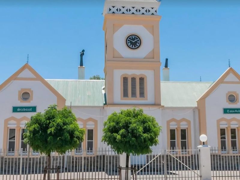 Front elevation of a well-maintained historic town hall building featuring a prominent central clock tower and symmetrical architectural design.