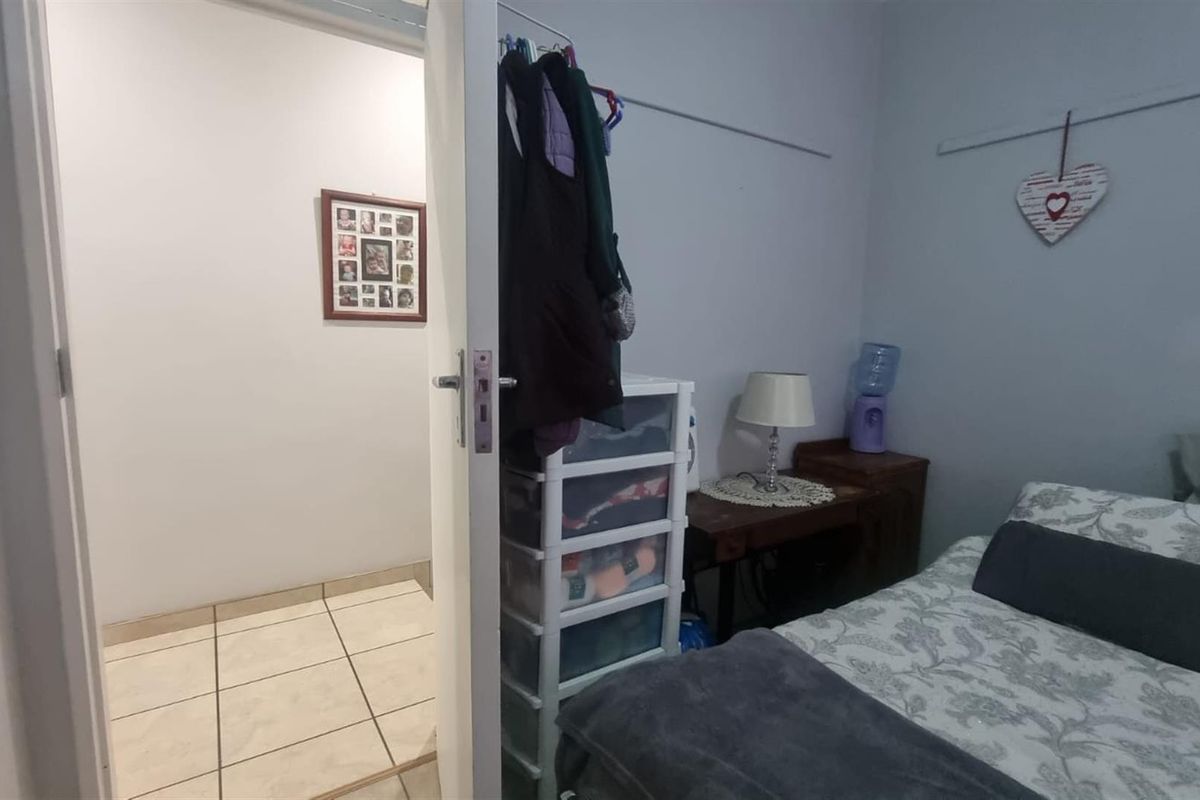A bedroom featuring tiled flooring in the adjacent hallway and standard interior finishes.