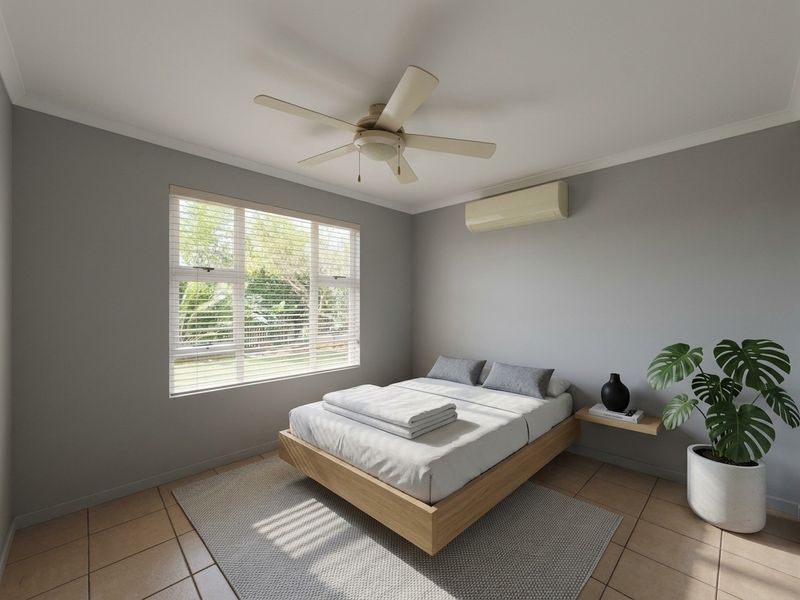 A well-maintained bedroom featuring tiled flooring, a ceiling fan, and a wall-mounted split-system air conditioner.