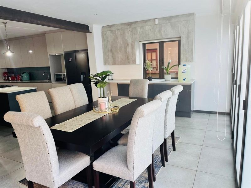 Open plan dining area featuring modern cabinetry, tiled flooring, and seamless flow into the adjacent kitchen space.