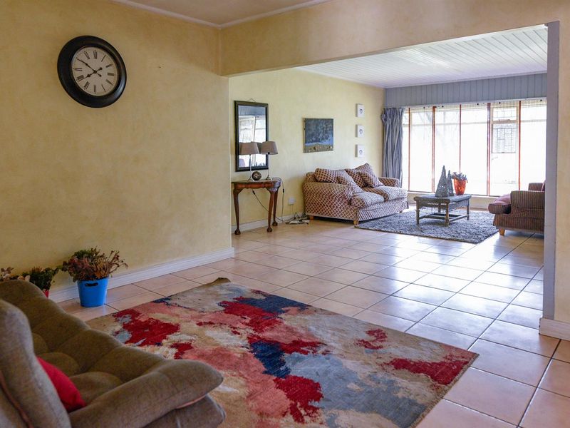 Spacious open-plan living area featuring neutral tiled flooring and large windows that provide ample natural light throughout the space.