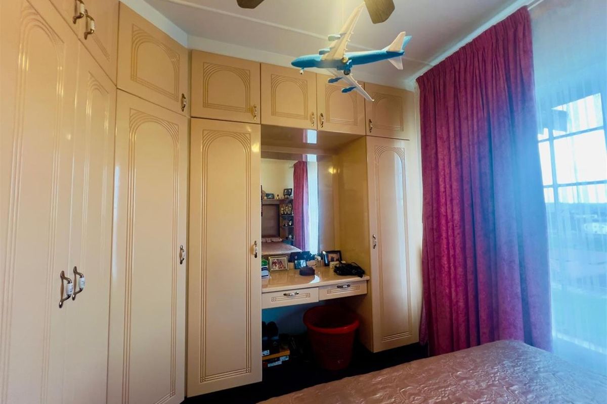A bedroom featuring extensive built-in cabinetry with an integrated vanity and mirror, providing ample storage space.