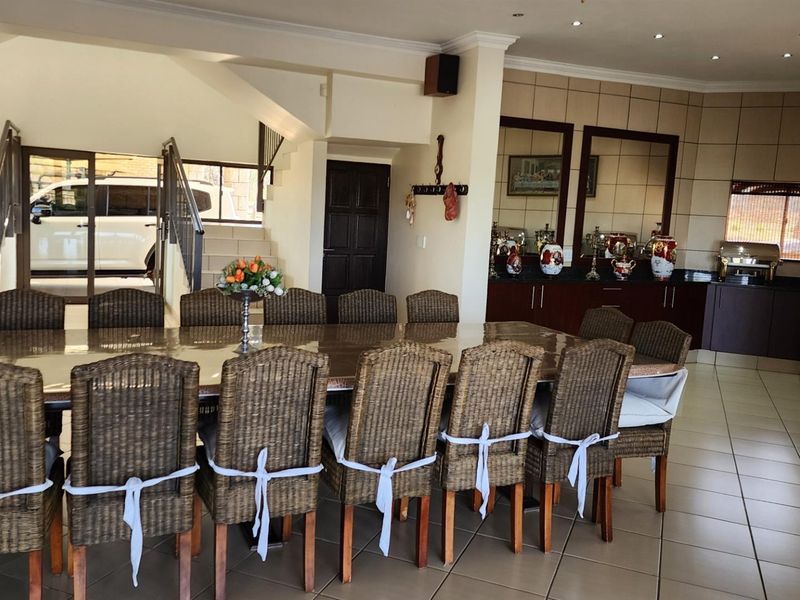 Spacious dining area featuring tiled flooring, built-in cabinetry, and an open-plan layout, providing a functional space for large gatherings.