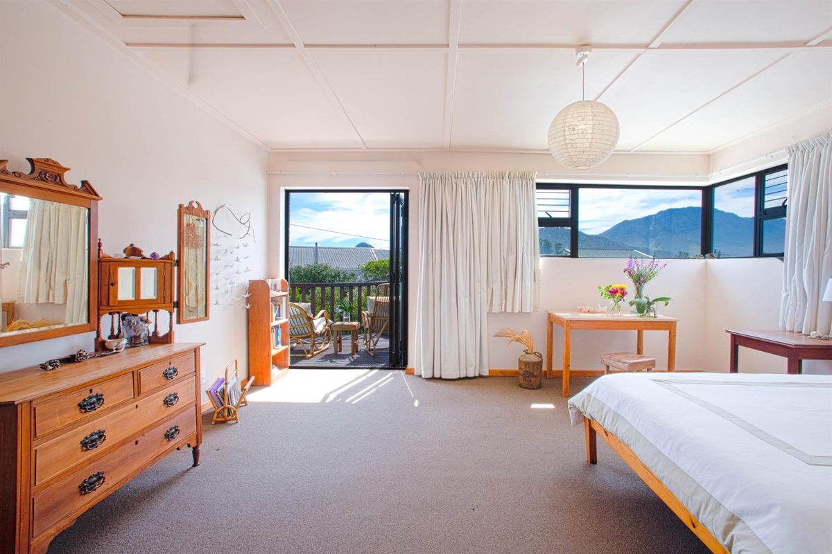 Spacious bedroom featuring carpeted flooring, a coffered ceiling, and direct access to a private balcony with mountain views.