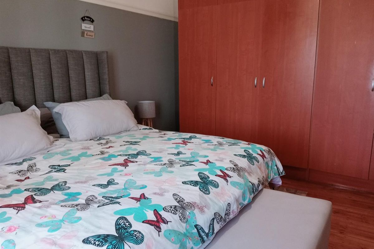 A bedroom featuring built-in wooden cabinetry and laminate flooring.