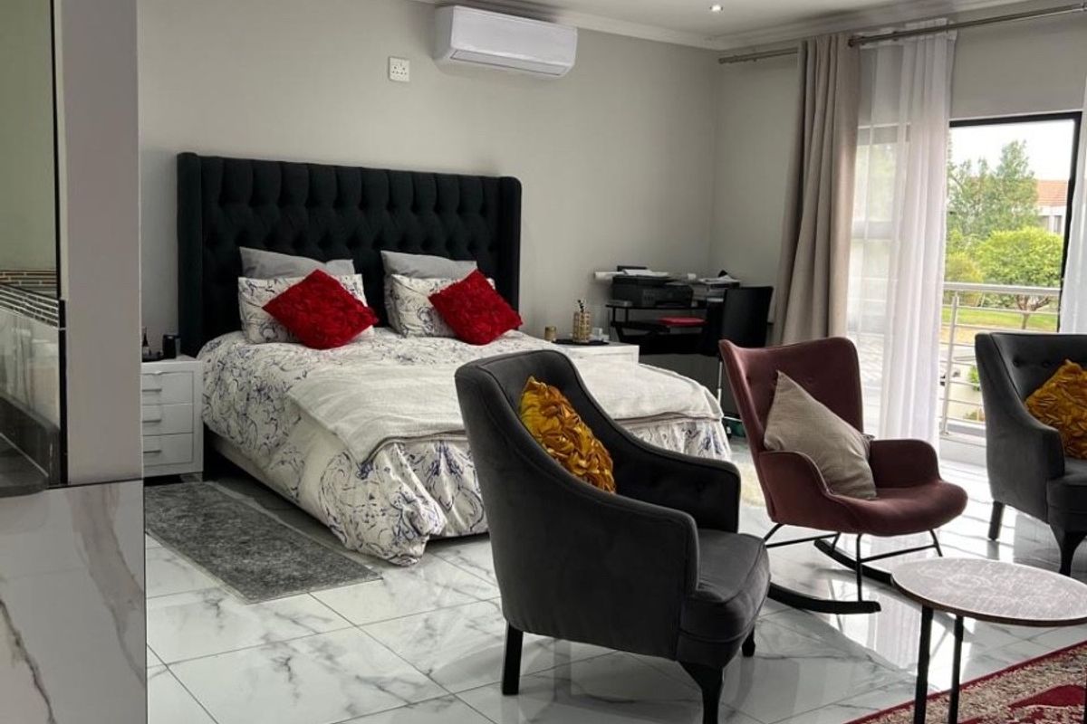 Spacious bedroom featuring modern marble-look floor tiles, recessed lighting, a ceiling fan, and a split-system air conditioner with direct access to a balcony.