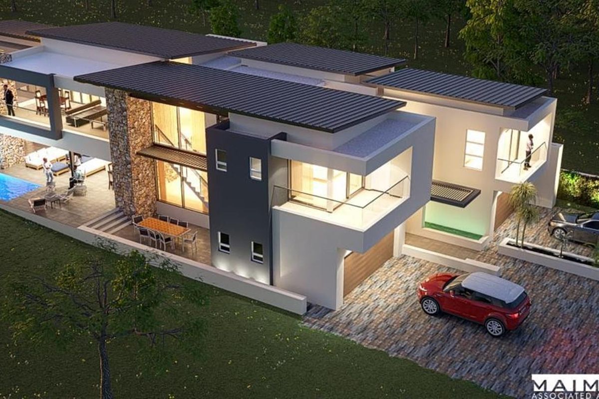 An aerial perspective of a modern luxury residence featuring stone accents, a swimming pool, multiple balconies, and a paved driveway.