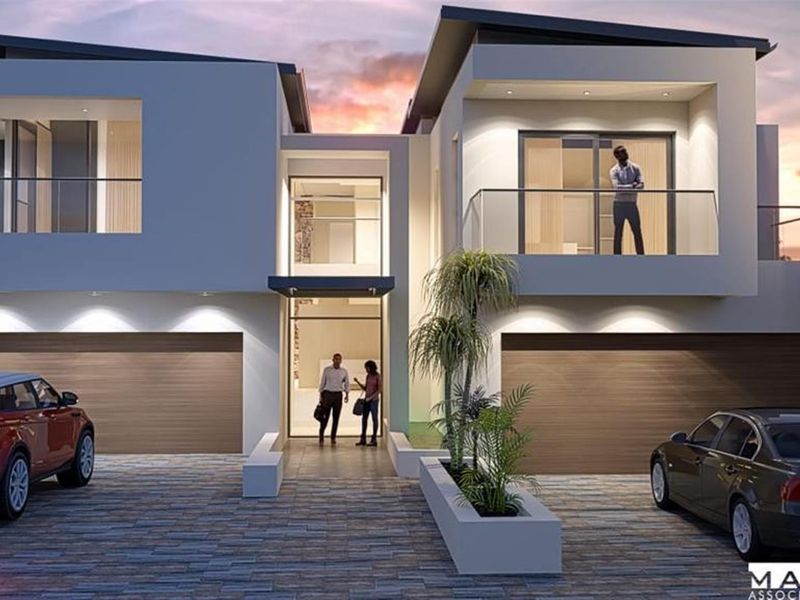 Modern double-story architectural residence featuring a double garage, paved driveway, and upper-level balcony with glass balustrades.