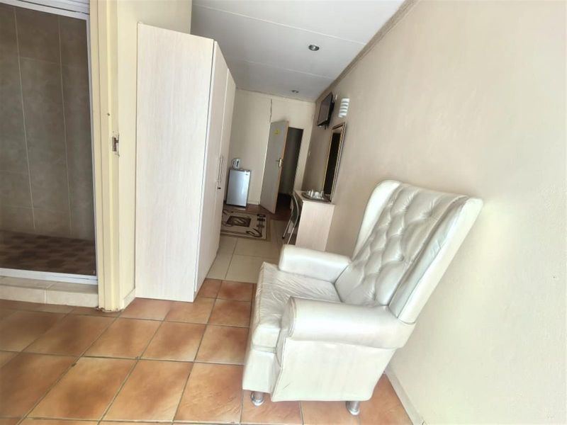 A bedroom featuring tiled flooring, built-in wardrobe storage, and direct access to an en-suite bathroom.