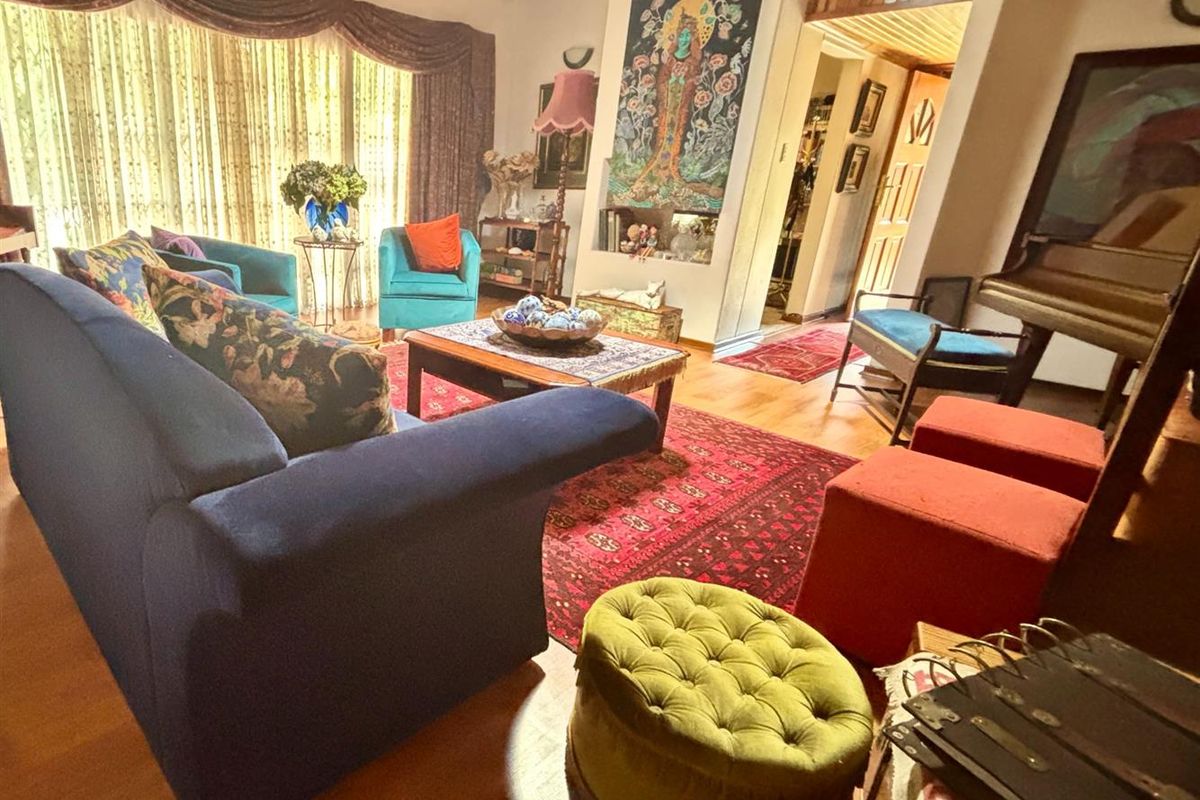 Spacious living room featuring warm timber ceilings and hardwood flooring, with a built-in wall niche and large windows allowing for natural light.