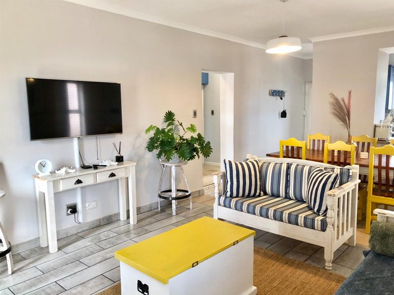 Open plan living and dining area featuring tiled flooring and neutral wall finishes, providing a functional and connected space for daily living.
