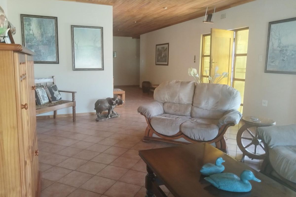Spacious living area featuring terracotta floor tiles and a timber-clad ceiling, providing a warm and rustic atmosphere.