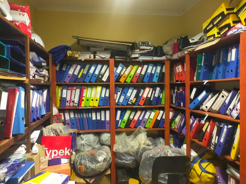 A utility storage room featuring extensive built-in shelving units currently utilized for document and supply storage.
