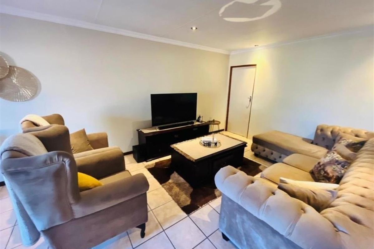 A comfortable living room featuring tiled flooring and recessed ceiling lighting, providing a functional and inviting space for relaxation.