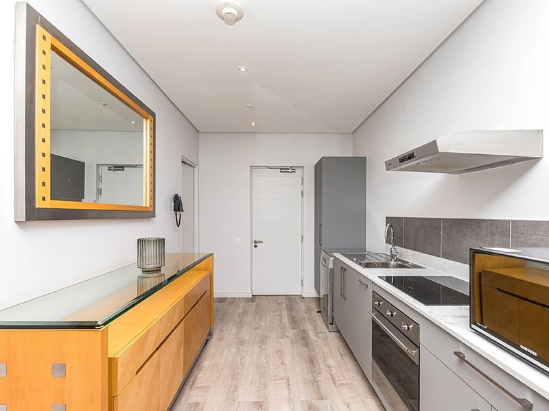 Modern kitchen featuring sleek grey cabinetry, stone countertops, integrated stainless steel appliances, and durable laminate flooring in a clean, contemporary layout.