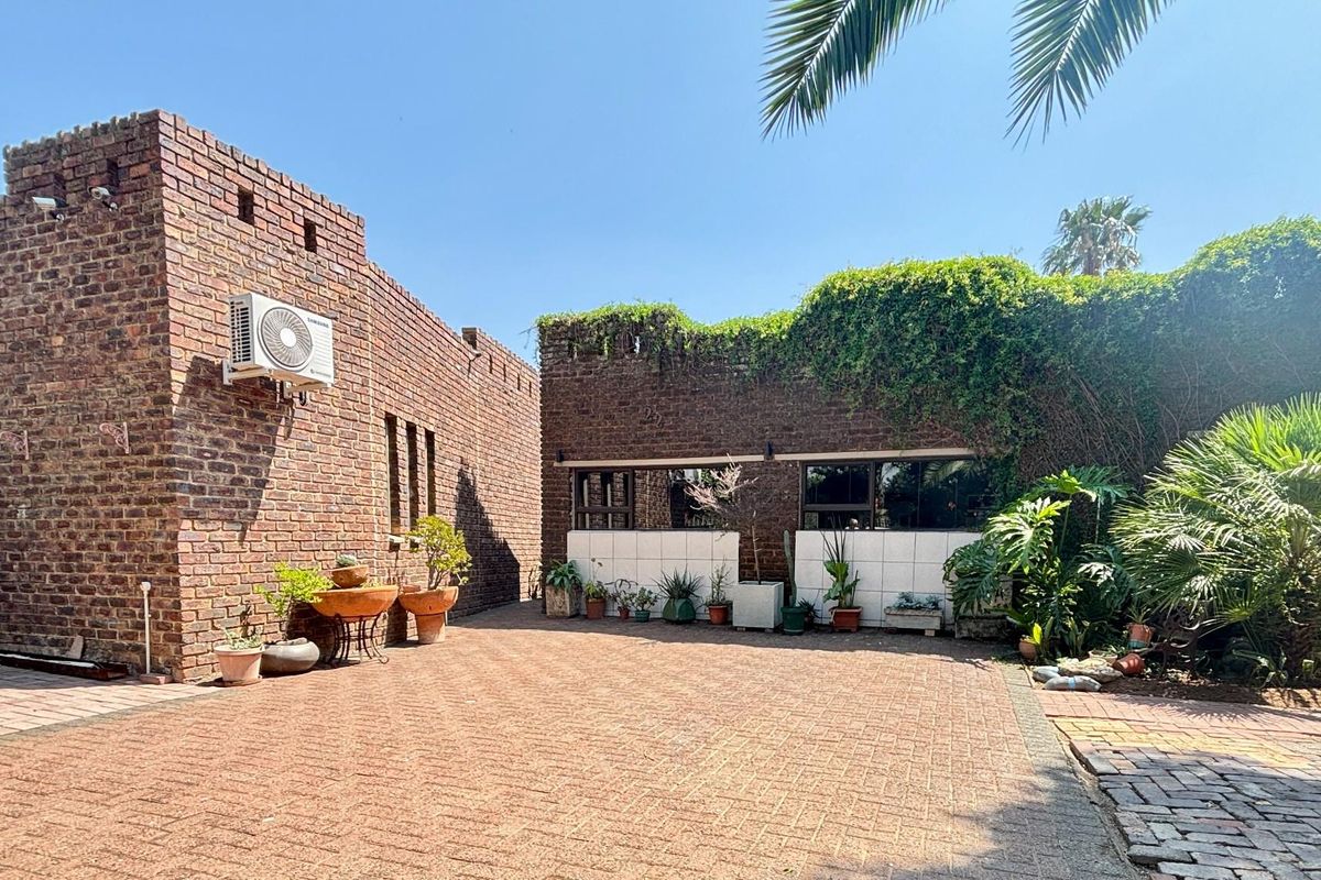 A private rear courtyard featuring face brick walls, paved flooring, and established climbing greenery, providing a secluded outdoor space.