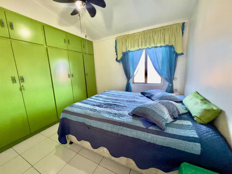 A bedroom featuring built-in floor-to-ceiling cabinetry and tiled flooring, providing functional storage space within the room.
