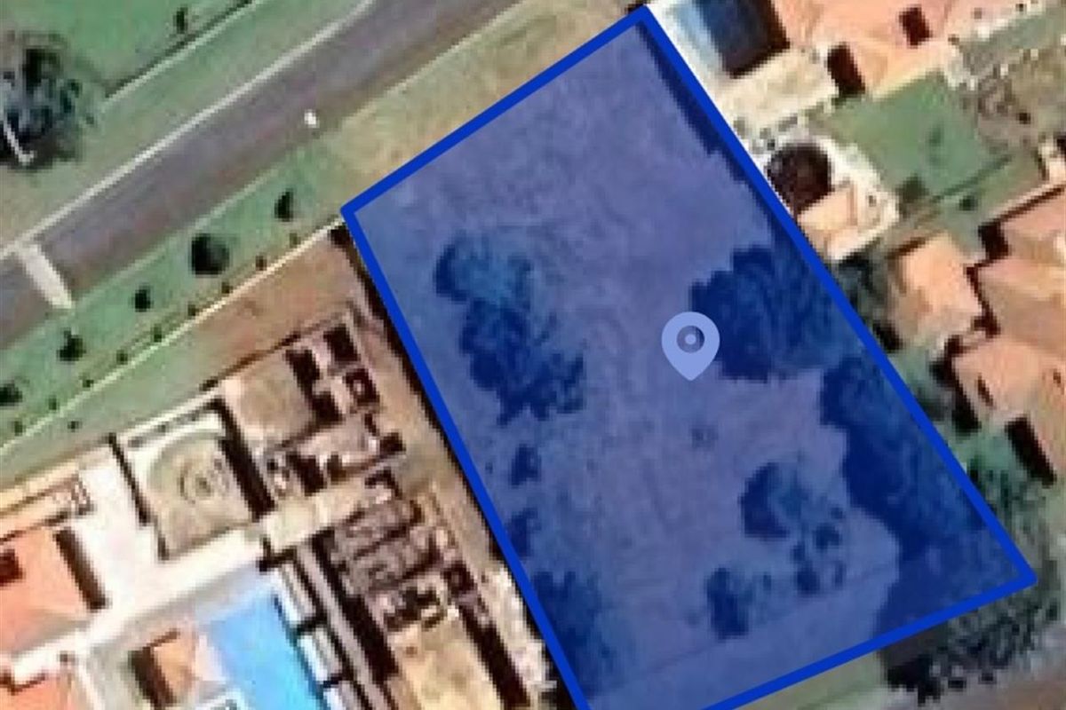 An aerial view of a vacant residential plot highlighted in blue, situated within an established suburban neighborhood.