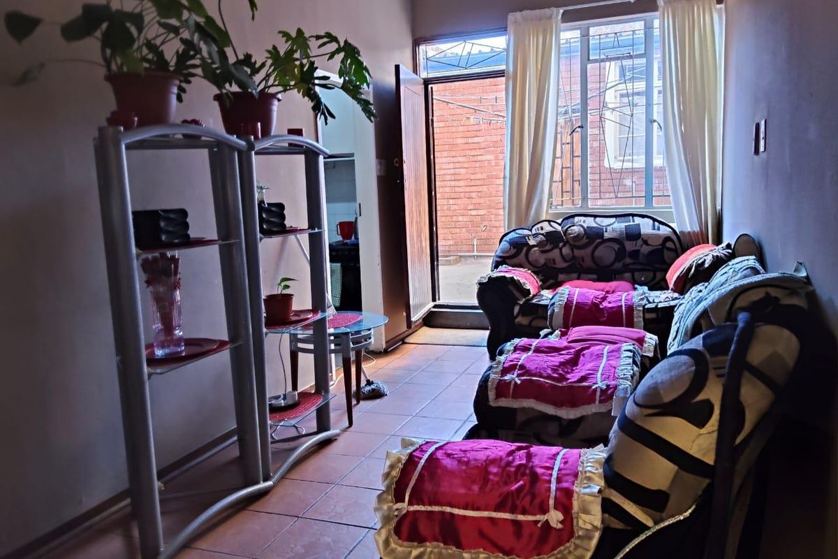 A living area featuring tiled flooring and direct access to an exterior space through a doorway.