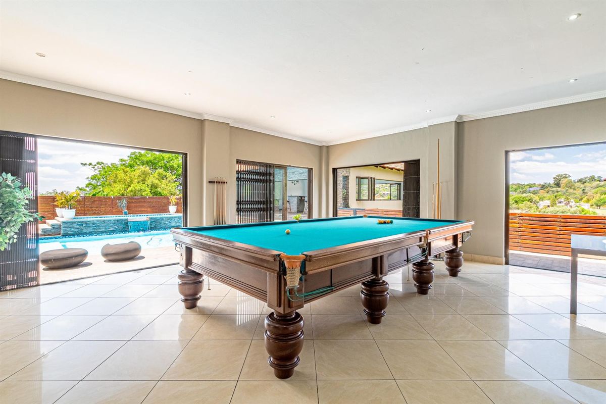 Spacious entertainment room featuring large sliding doors opening to a pool area, tiled flooring, and recessed ceiling lighting.